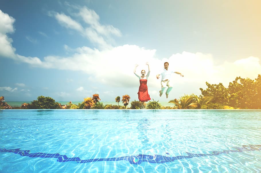 woman man dressed up jumping into pool